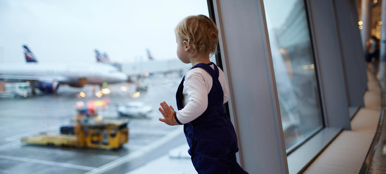 Child looking out from the airport lounge